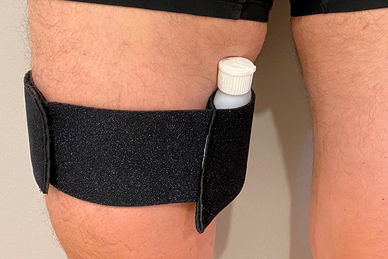 a person wearing a black band around a white bottle